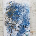 Kort med blomst i guld og teksten "Tillykke"